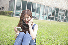 芝生に座って写真を撮る女性