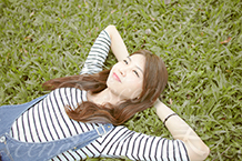 芝生に寝そべりながら甘えてくる彼女 美人女性モデルの写真素材なら美scene
