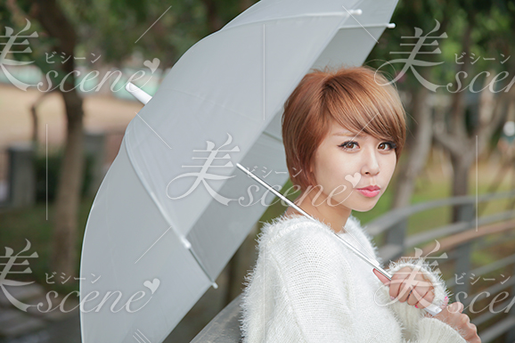 雨の日に傘をさして現れた茶髪の女性