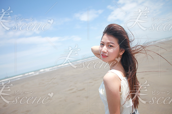 風になびく白い服の女性モデル