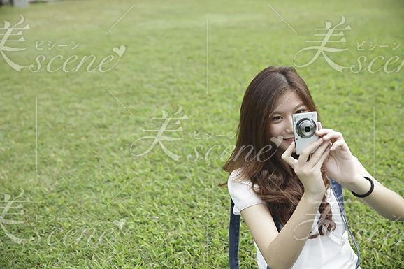 芝生で写真を撮る女性