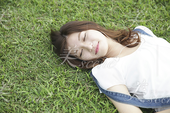 芝生でうたた寝をする女性