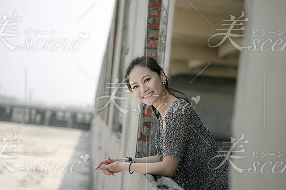 窓から顔を出し笑いかける女性