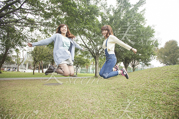 芝生の上でジャンプする女性二人