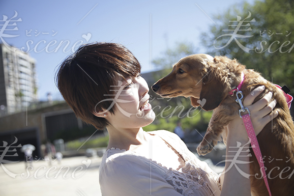 公園で愛犬を抱き上げるが犬は笑わない 美人女性モデルの写真素材なら美scene