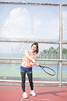 テニスラケットでスイングの練習をする女性