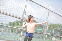 テニスのサーブの練習をする女子高生