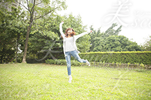 芝生の上でジャンプする女性