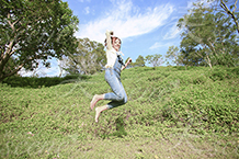 芝生でマリオジャンプする裸足の女性