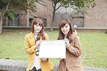 ホワイトボードを女性二人で持つ写真素材