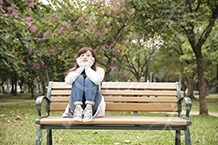 公園のベンチに座るカジュアルな服の女の子